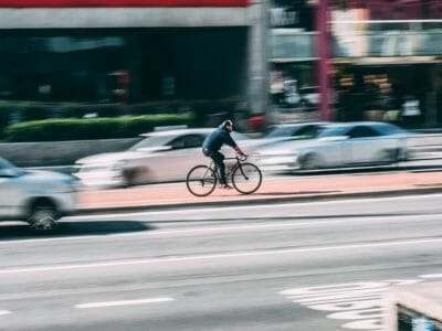 Biker zooming dangerously in traffic who should read our ultimate guide to safety on Tucson bike routes.