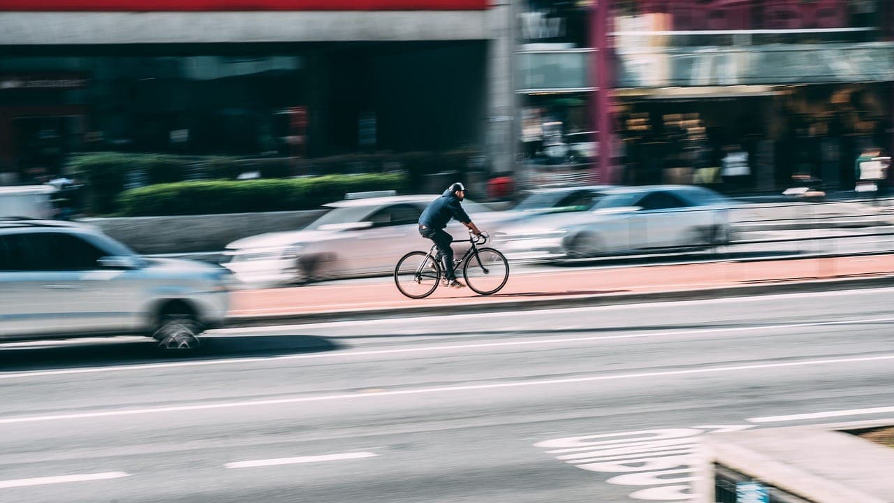 Biker zooming dangerously in traffic who should read our ultimate guide to safety on Tucson bike routes.